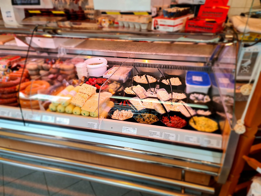 Frischetheke mit regionalen Käseprodukten und Salaten in einer unserer Filialen
