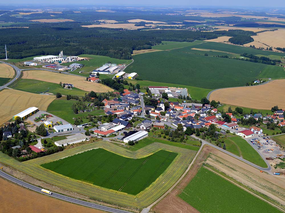 Luftaufnahme des Ortes Dittersdorf, auf der auch die angrenzenden Felder der Landgenossenschaft zu sehen sind